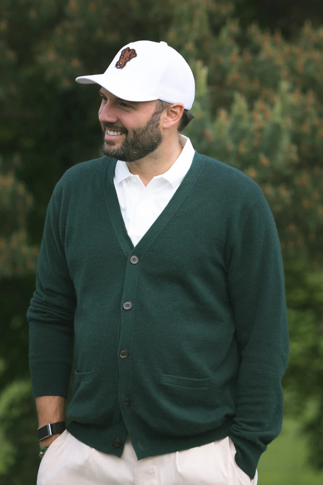 Green cardigan worn open over a white polo